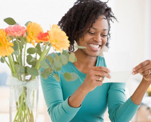 woman reading card next to flowers